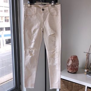 American Eagle ripped cream-colored jeans